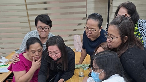 Small group in the Philippines looking at training material around a table.
